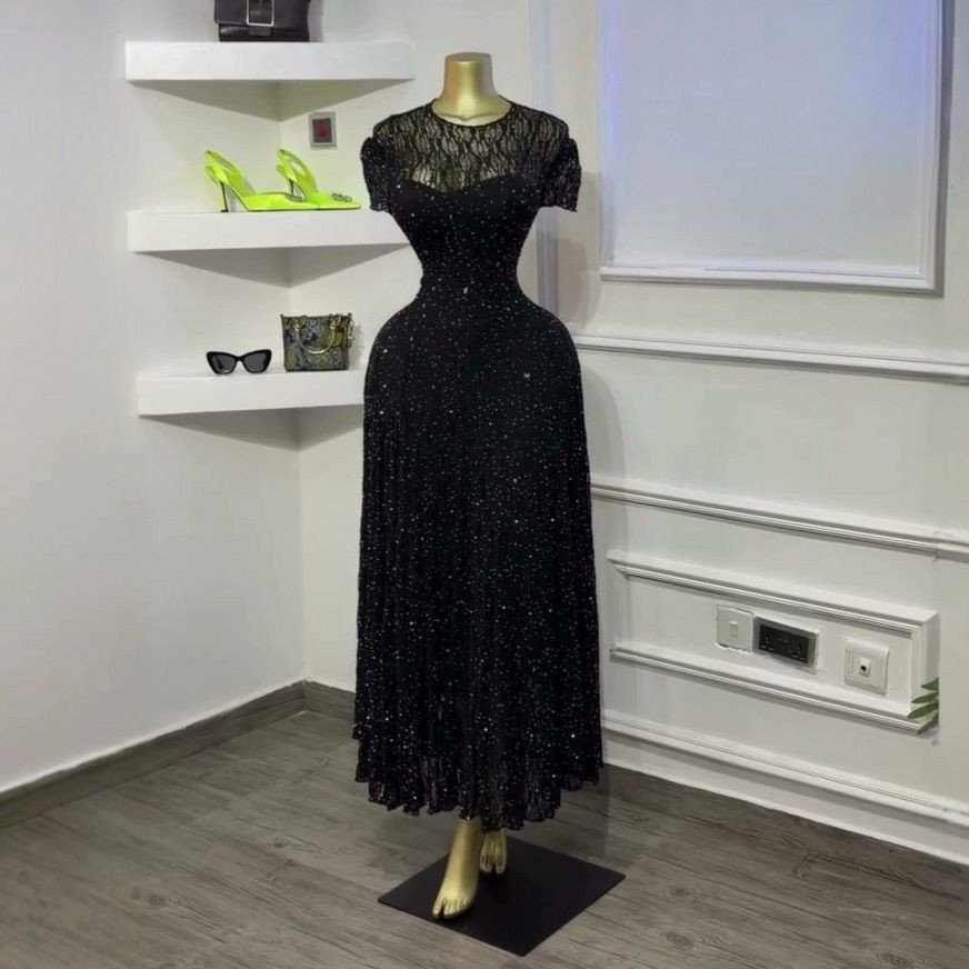 Robe midi en dentelle blanche qui présente un délicat haut transparent à manches courtes.
