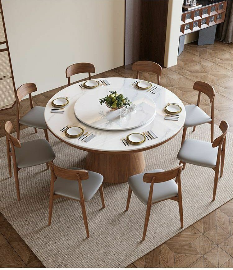 Table à manger ronde moderne en bois avec un plateau en pierre frittée et un plateau tournant central (type Lazy Susan), accompagnée de huit chaises assorties au dossier incurvé et à l'assise grise.