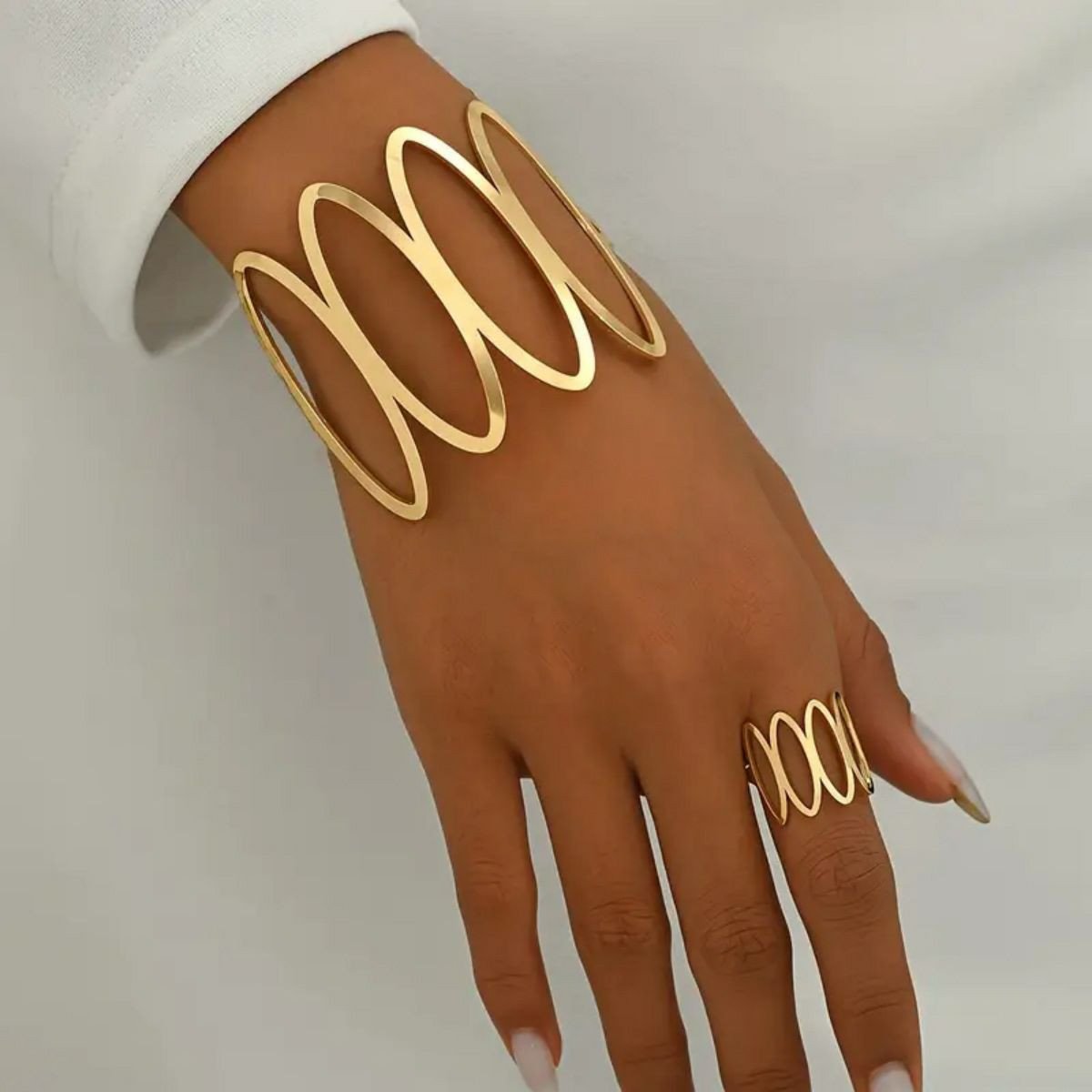 Ensemble de bijoux dorés se distingue par son design géométrique audacieux composé d'une bague assortie